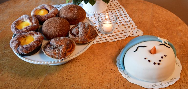 Bild på bullar och tårta som ser ut som en snögubbe