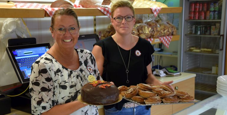 Tjejerna på fiket visar upp tårta och bullar