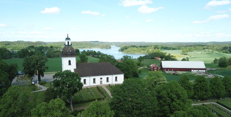 Vy över Tjärstad kyrka med vackra omgivningar
