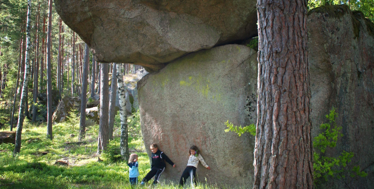 Tre små barn vid stenblocken